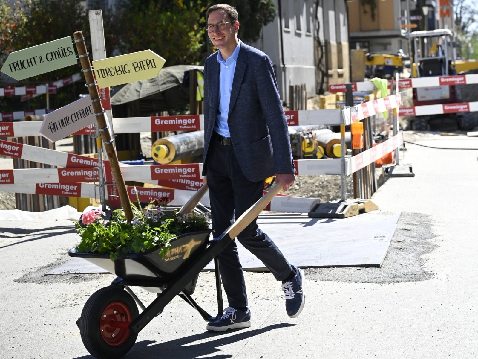 Sieht man nicht alle Tage: Stadtpräsident Simon Wolfer fährt eine bepflanzte Karrette durch das Stadtzentrum. (Bild: Stadt Weinfelden)